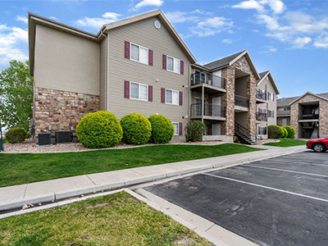 Three-story Hillcrest condominium building in Saratoga Springs, Utah with stone accents and surface parking